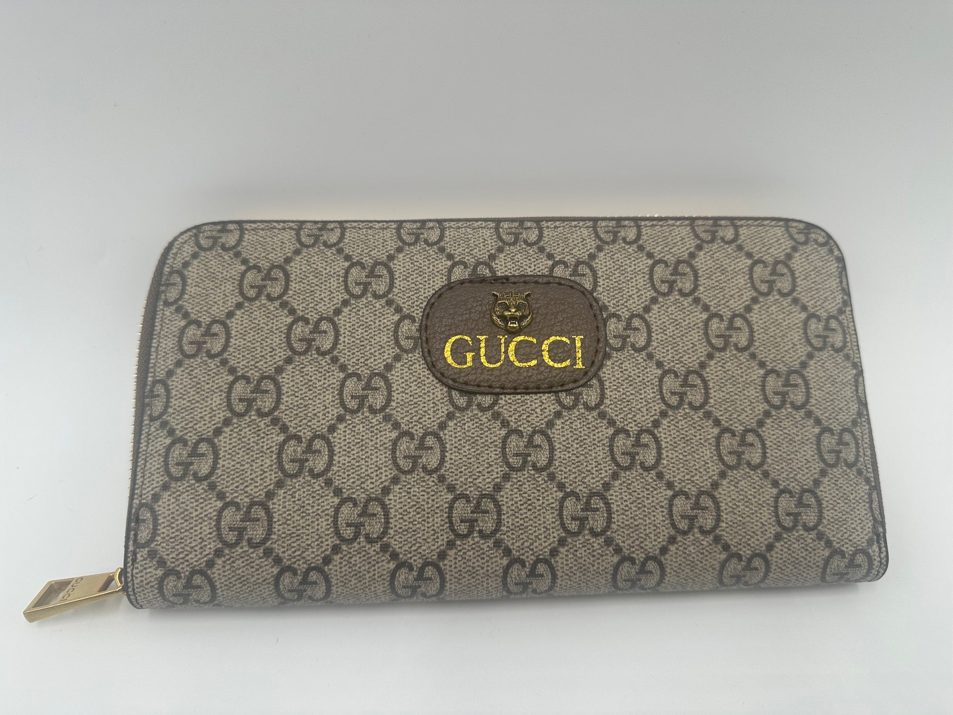 Gucci wallet with monogram pattern on a white background