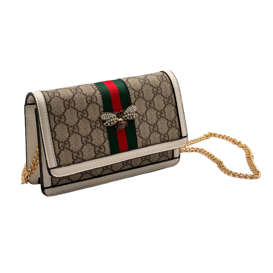 Designer handbag with chain strap on a light gray background