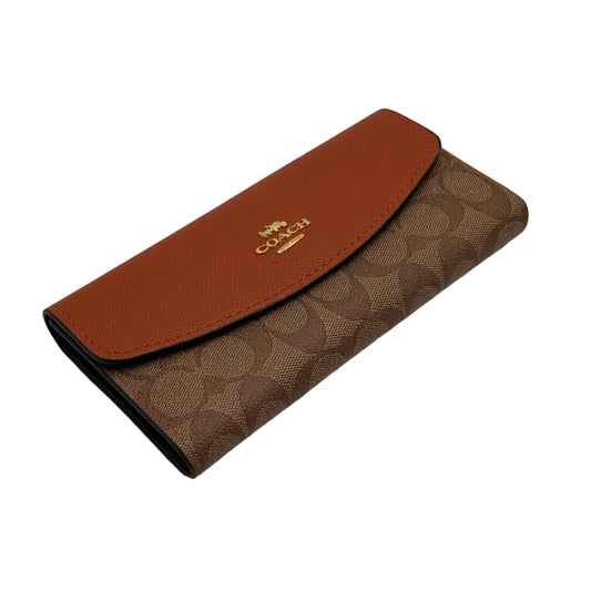 Brown wallet with a visible brand logo on a beige background