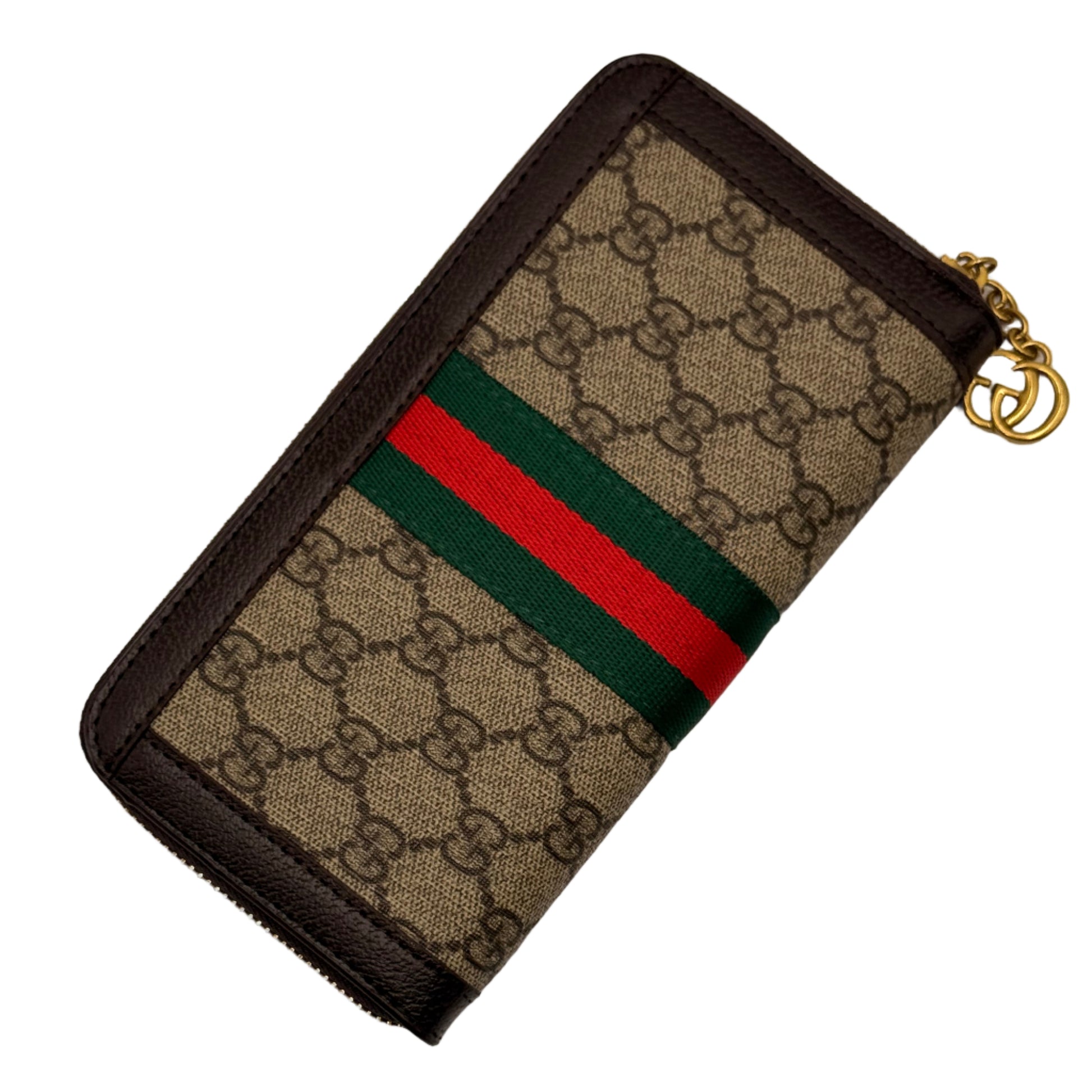 Gucci wallet with monogram pattern and red and green stripe on a light gray background