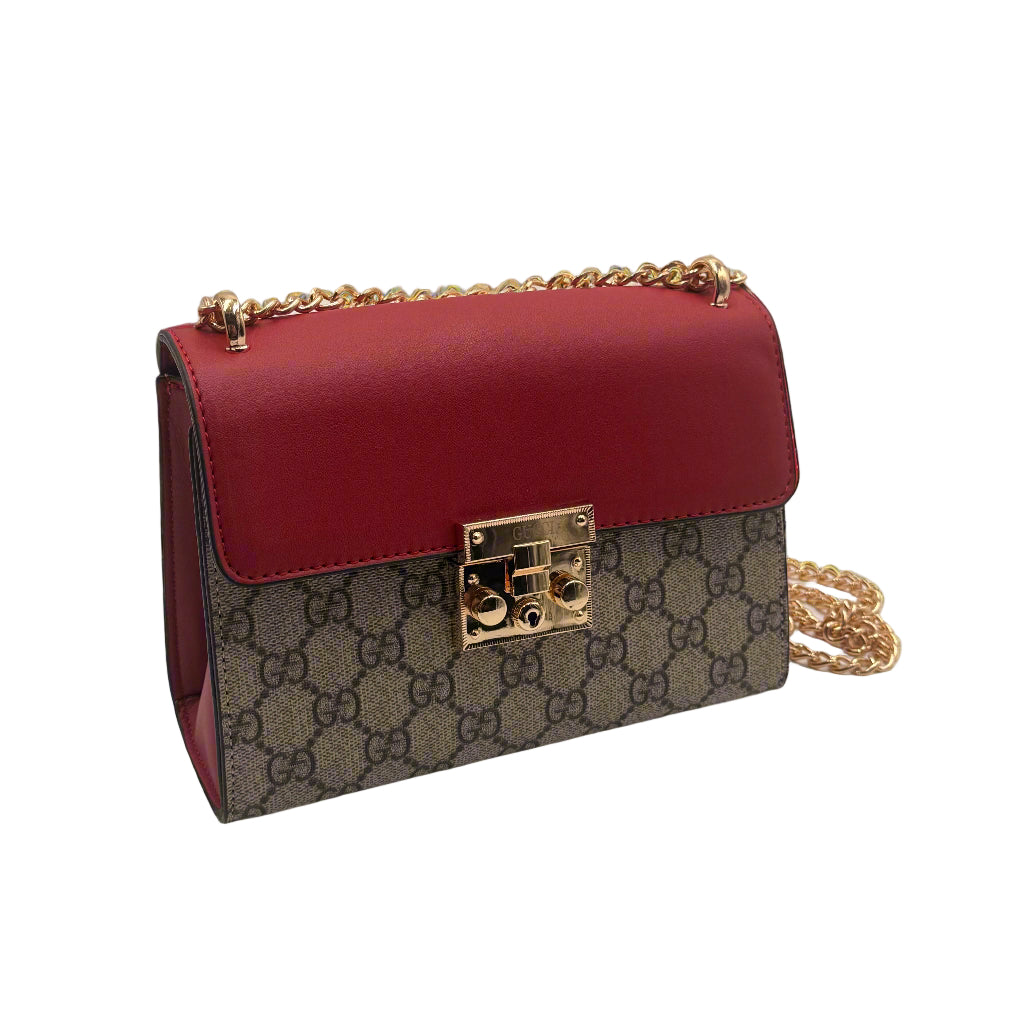 Designer handbag with red leather and patterned body on a light gray background