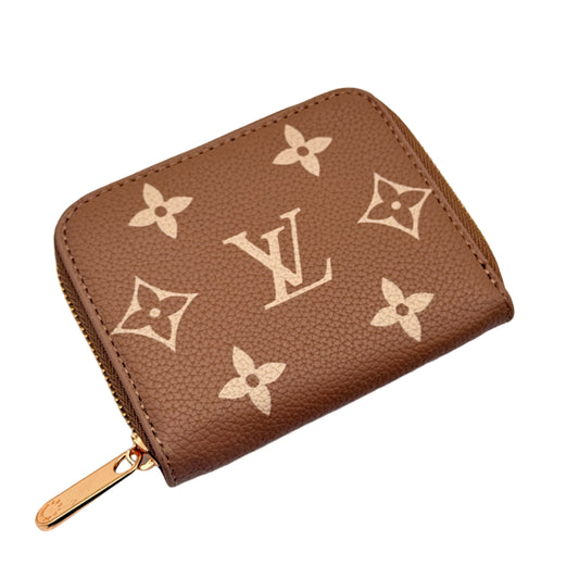 Brown wallet with a brand logo on a light gray background