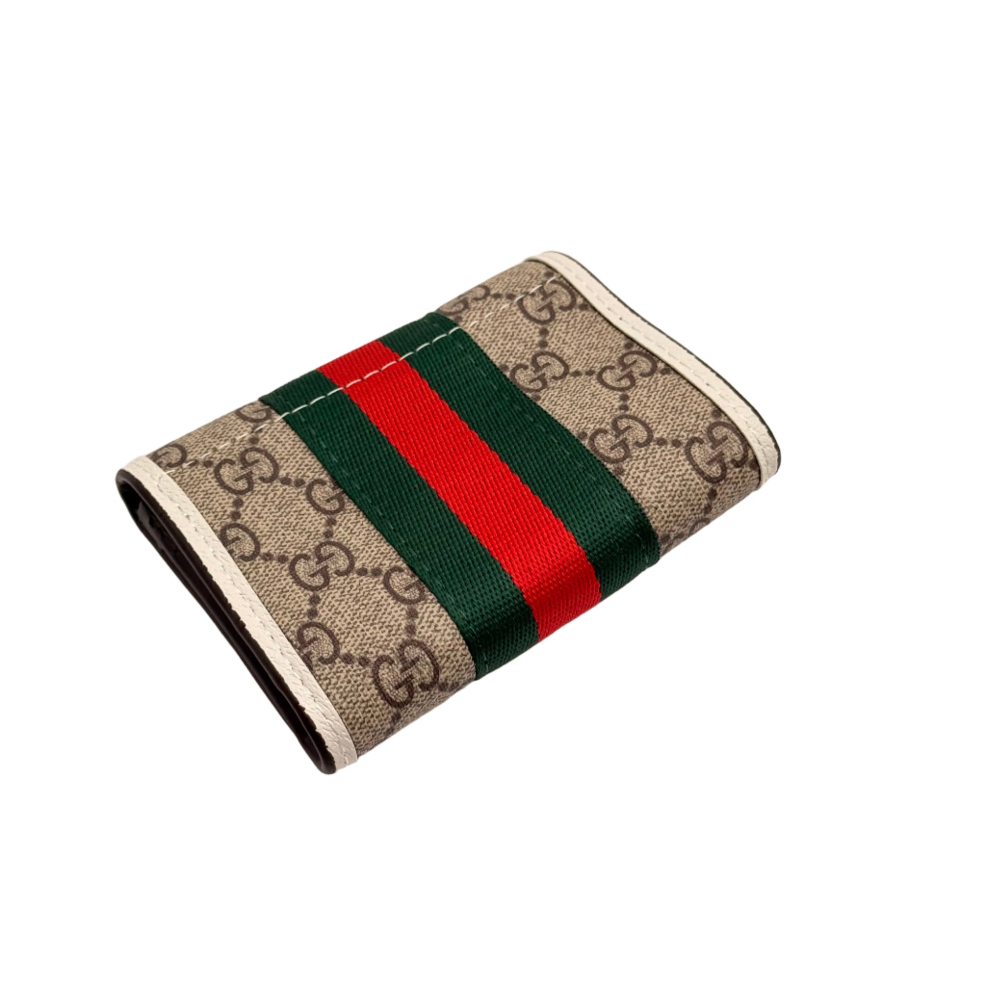 Gucci wallet with iconic pattern and red and green stripe on a light gray background