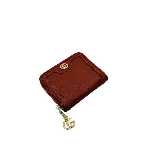 Brown wallet with gold chain on a light gray background