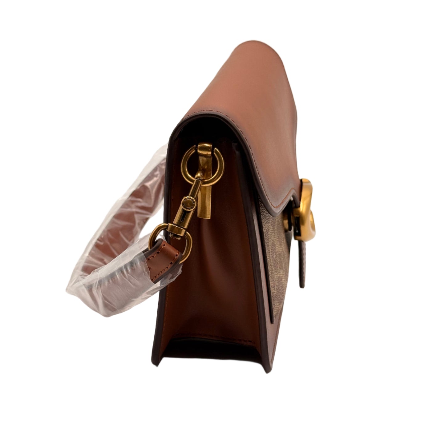 Close-up of a brown leather handbag with gold hardware on a light gray background