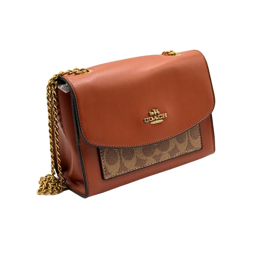 Brown handbag with gold chain on a light beige background