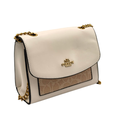 White handbag with gold chain strap on a light gray background