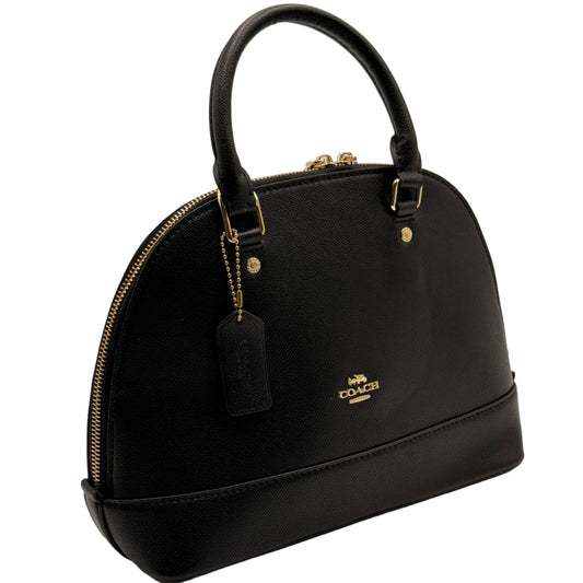 Black handbag with gold accents on a light gray background