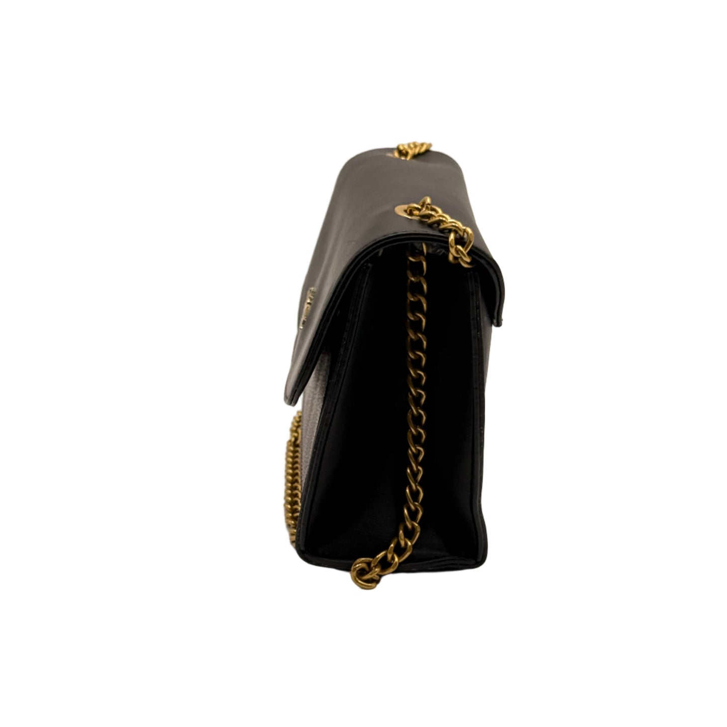 Black handbag with gold chain strap on a light beige background