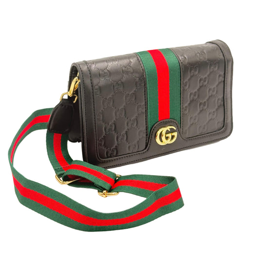 Black textured wallet with red and green strap on a beige background